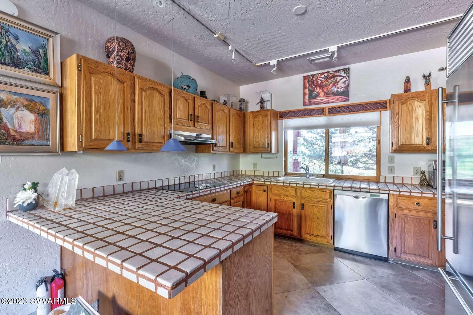25 Homestead Road Sedona, AZ 86336 - Photo 16 of 25 a kitchen with stainless steel appliances granite countertop a stove a sink dishwasher and cabinets with wooden floor