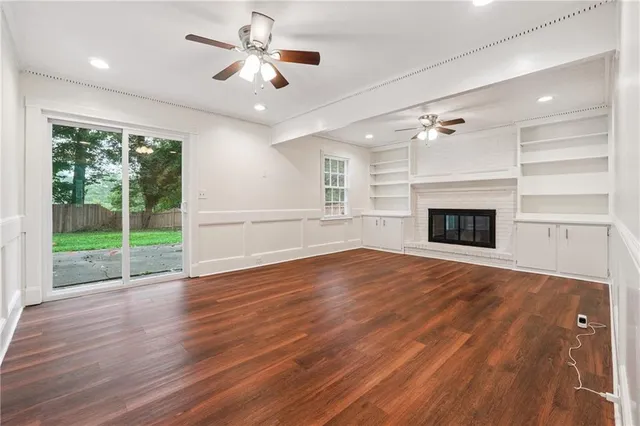 a view of empty room with wooden floor and fireplace