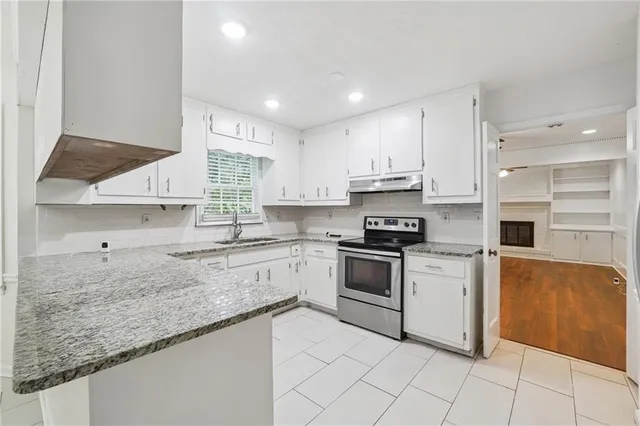 a kitchen with granite countertop white cabinets and white appliances