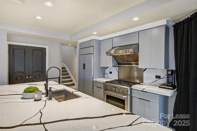 a kitchen with kitchen island granite countertop a stove a sink and a refrigerator