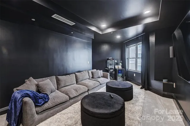a living room with furniture a flat screen tv and a large window