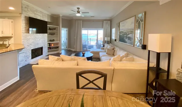 a living room with stainless steel appliances kitchen island granite countertop a stove and a view of living room