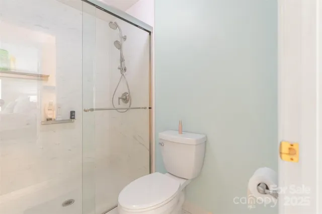 a white toilet sitting next to a bathroom shower