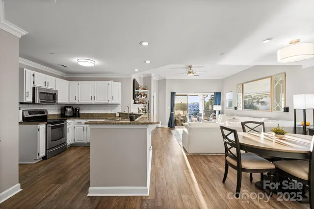a kitchen with a table chairs microwave and cabinets