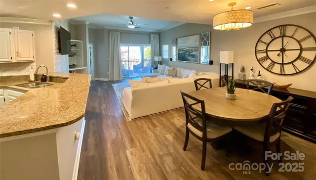 a dining room with wooden floor a chandelier a glass table and chairs