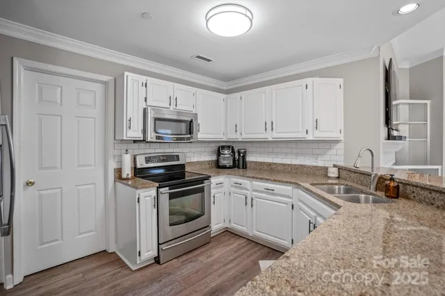 a kitchen with granite countertop a sink and a stove top oven