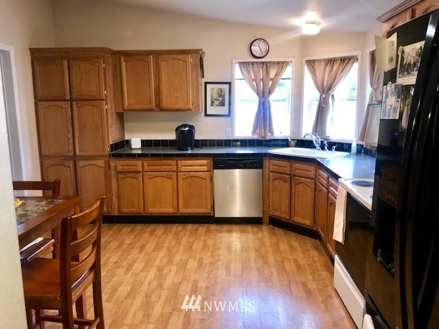 18937 Guava Street Southwest Rochester, WA 98579 - Photo 7 of 25 a kitchen with stainless steel appliances granite countertop a sink stove and cabinets