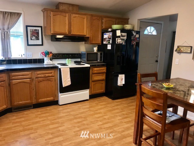 18937 Guava Street Southwest Rochester, WA 98579 - Photo 8 of 25 a kitchen with stainless steel appliances granite countertop a stove refrigerator and sink