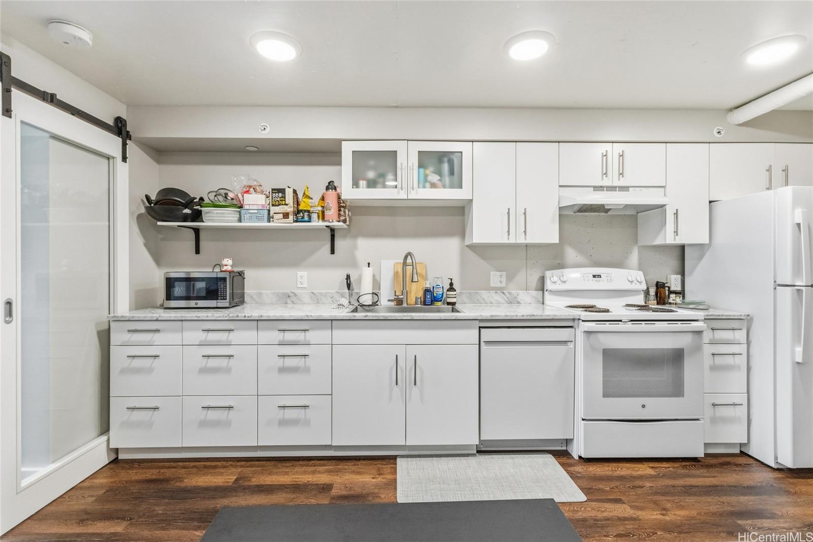 803 Waimanu Street, Unit 702 Honolulu, HI 96813 - Photo 2 of 19 a kitchen with stainless steel appliances granite countertop a refrigerator and a stove top oven