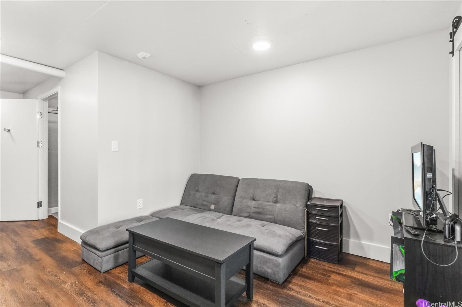 803 Waimanu Street, Unit 702 Honolulu, HI 96813 - Photo 5 of 19 a bedroom with furniture and a wooden floor
