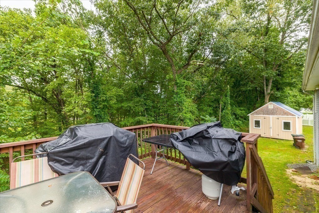 6 Nancy Drive Auburn, MA 01501 - Photo 25 of 27 a view of a patio with table and chairs under an umbrella a barbeque