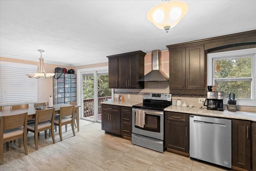 6 Nancy Drive Auburn, MA 01501 - Photo 5 of 27 a kitchen with stainless steel appliances granite countertop wooden cabinets a stove a sink a dining table and chairs