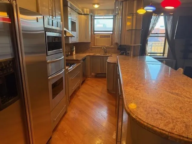 a kitchen with stainless steel appliances granite countertop a sink a stove and a refrigerator