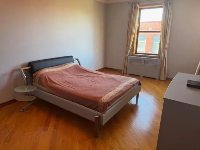 a bed sitting in a bedroom next to a window