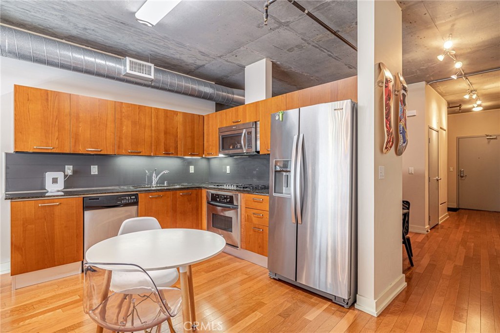 645 West 9th Street, Unit 301 Los Angeles, CA 90015 - Photo 2 of 14 a kitchen with stainless steel appliances granite countertop a refrigerator and a stove