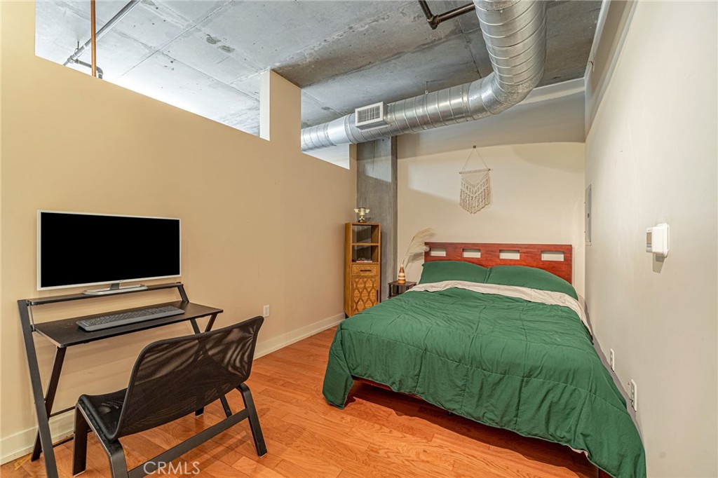 645 West 9th Street, Unit 301 Los Angeles, CA 90015 - Photo 6 of 14 a bedroom with a bed and a chair