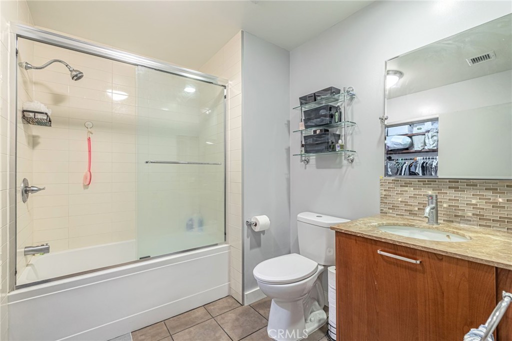 645 West 9th Street, Unit 301 Los Angeles, CA 90015 - Photo 8 of 14 a bathroom with a granite countertop sink toilet and shower