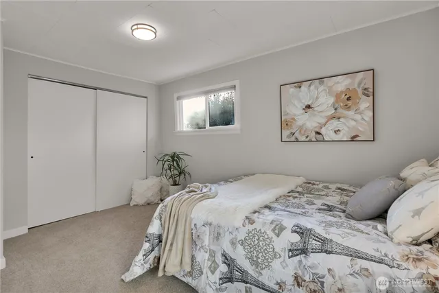 a bedroom with a bed and a painting on the wall