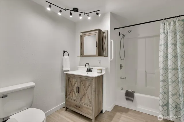 a bathroom with a granite countertop sink toilet a shower and a mirror