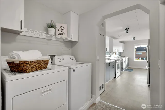 a view of washer and dryer with kitchen in the background