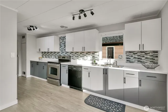a kitchen with granite countertop a sink cabinets and stainless steel appliances