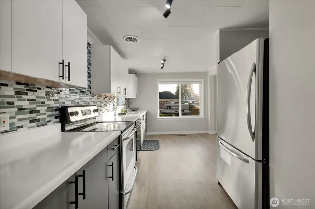 a kitchen with stainless steel appliances a stove a sink and a refrigerator