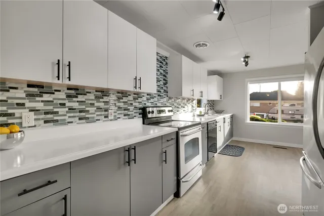 a kitchen with stainless steel appliances a sink a stove and a window