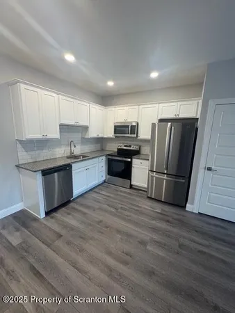 a kitchen with stainless steel appliances granite countertop a refrigerator sink and stove