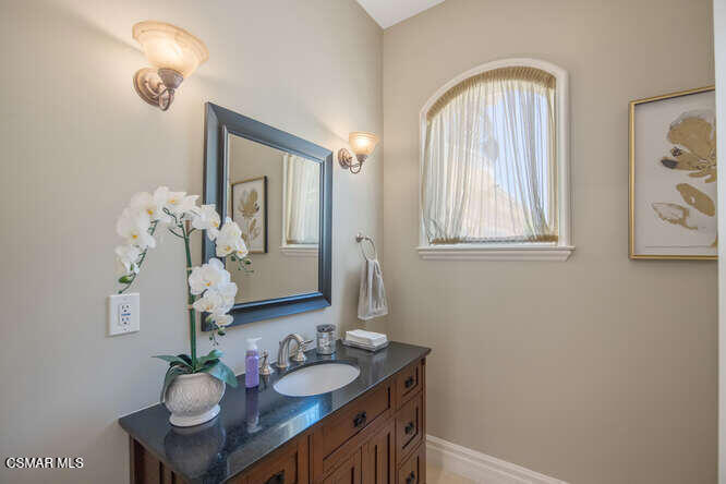 421 Whitegate Road Newbury Park, CA 91320 - Photo 13 of 76 a bathroom with a granite countertop sink a mirror and a window