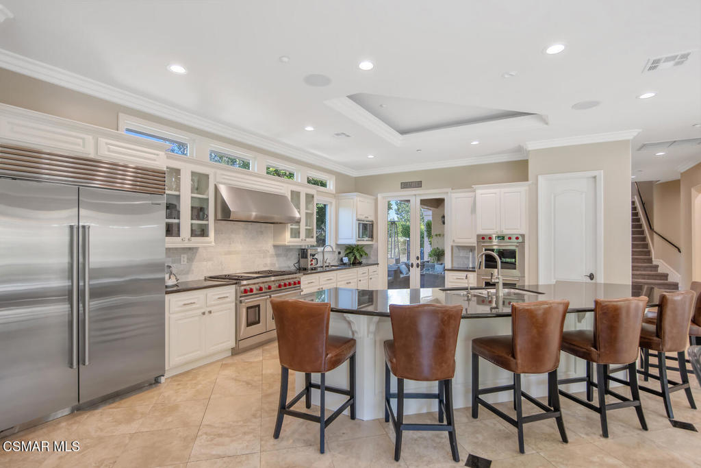 421 Whitegate Road Newbury Park, CA 91320 - Photo 17 of 76 a kitchen with stainless steel appliances kitchen island granite countertop a table chairs sink and cabinets