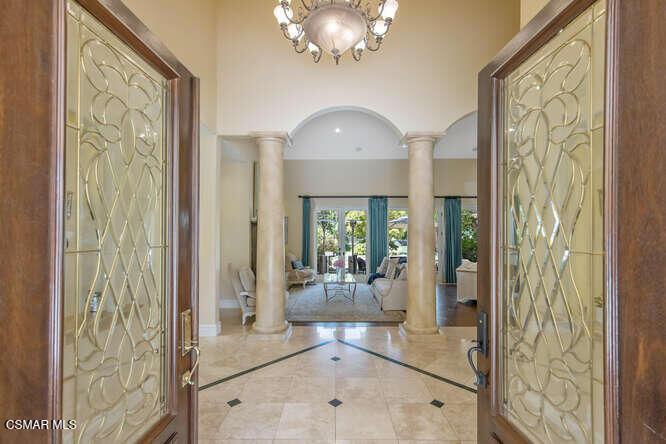 421 Whitegate Road Newbury Park, CA 91320 - Photo 3 of 76 a view of a hallway with wooden floor and a chandelier