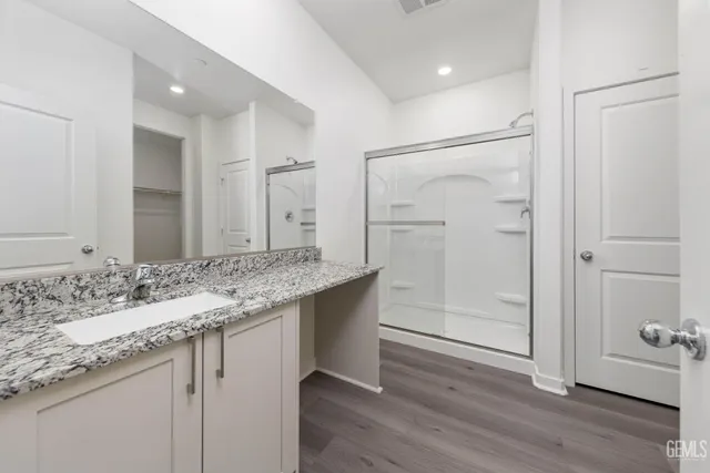 a bathroom with a granite countertop sink and a mirror