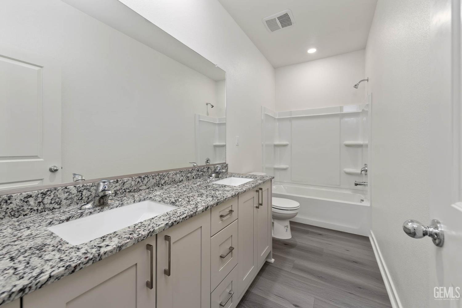 Undisclosed Address Bakersfield, CA 93313 - Photo 6 of 10 a bathroom with a granite countertop sink a toilet and a bathtub