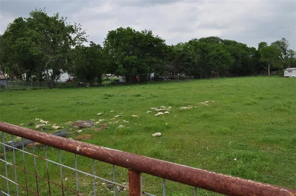 a view of a green field of grass and trees