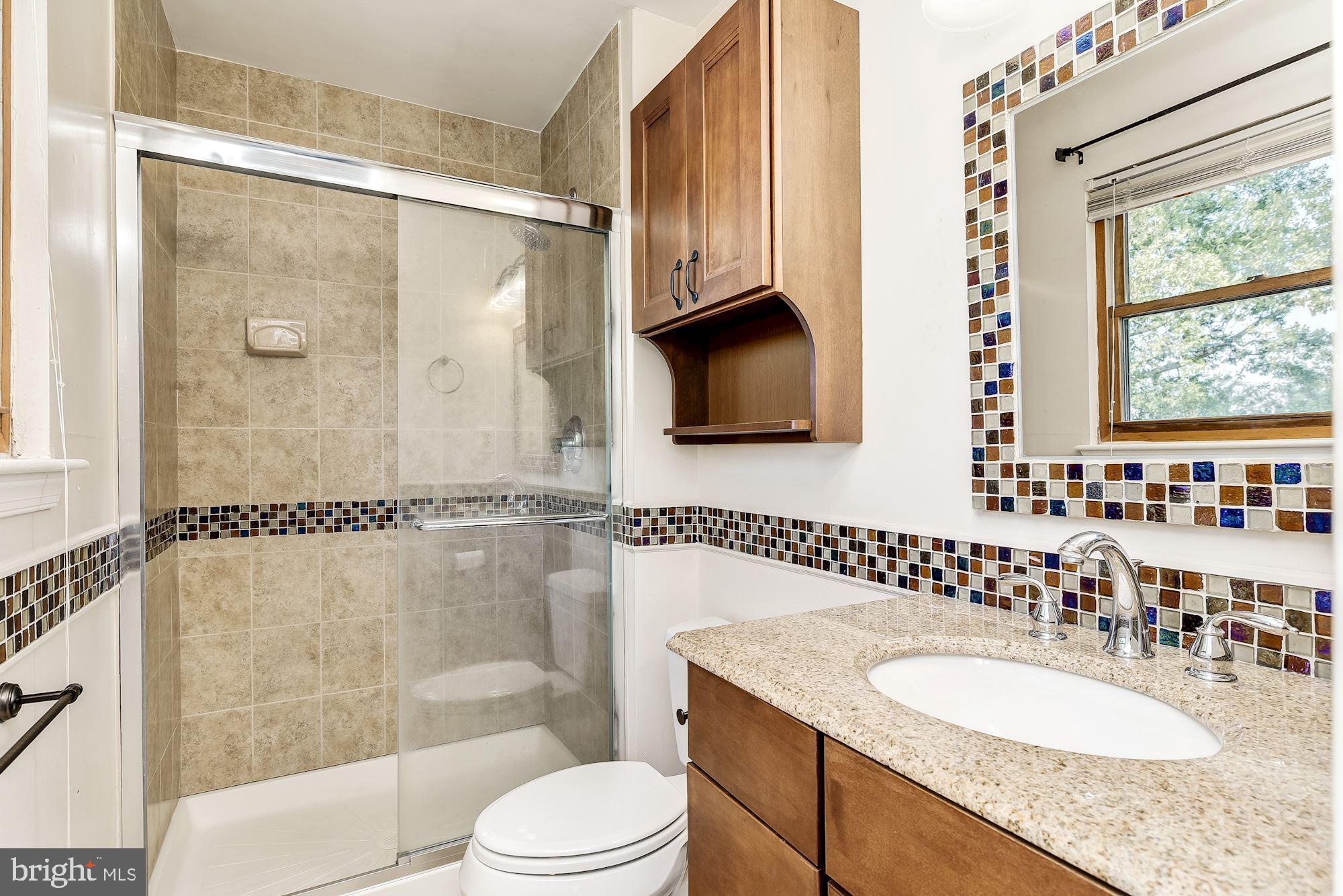 3069 Riverview Road Riva, MD 21140 - Photo 21 of 38 a bathroom with a granite countertop sink toilet a mirror and shower