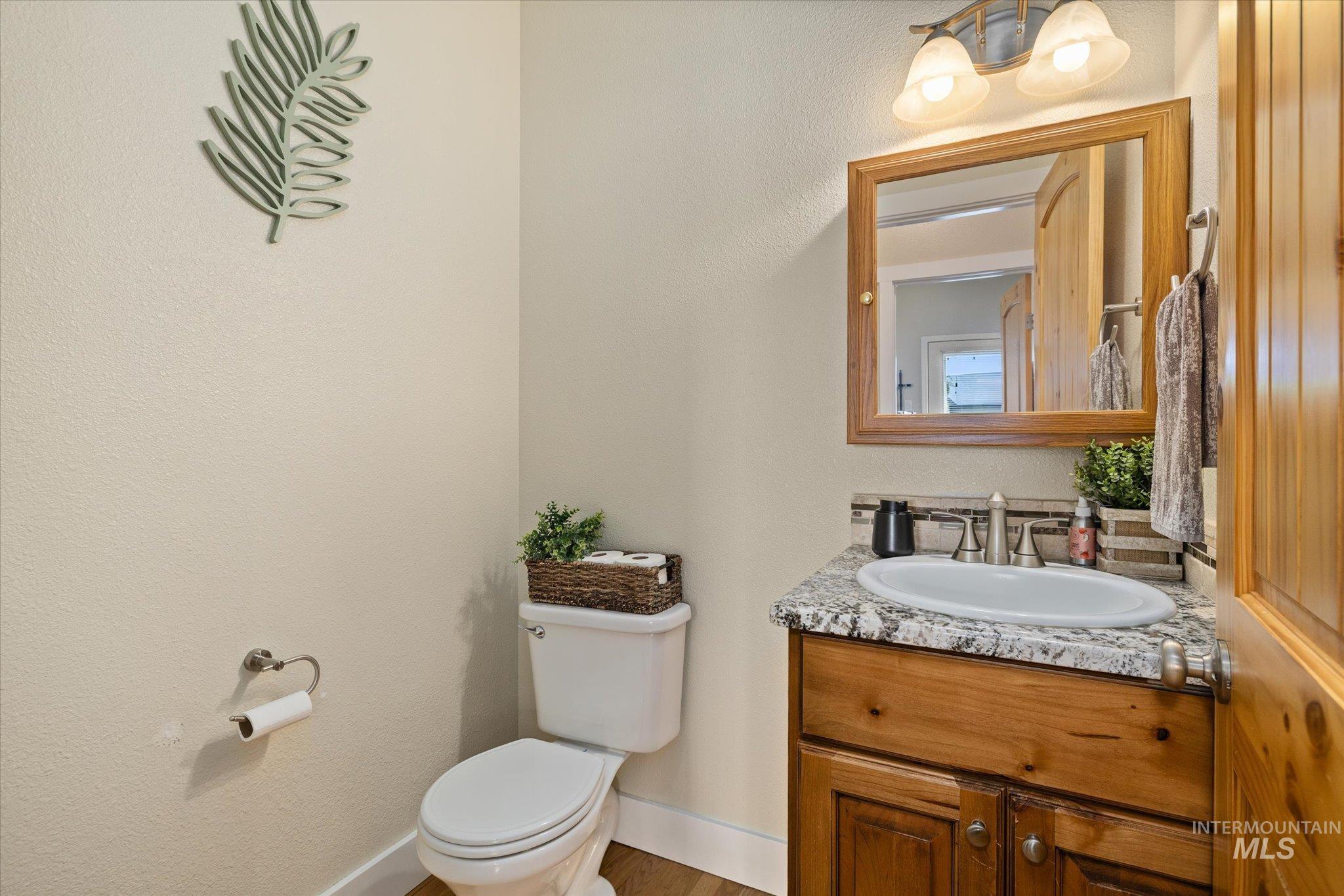 1140 Edgemont Road Emmett, ID 83617 - Photo 21 of 50 Bathroom featuring a wood vanity with a granite-style countertop, a white oval sink, and a tiled backsplash