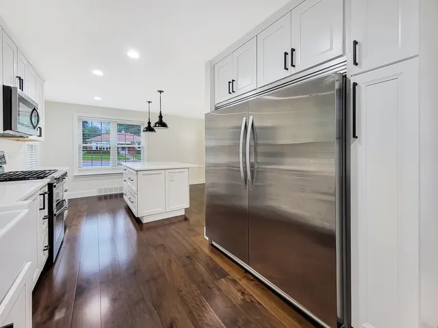 a kitchen with white cabinets and stainless steel appliances