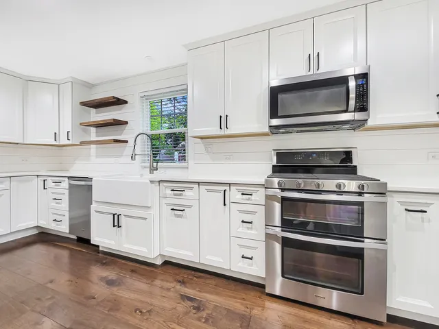 a kitchen with white cabinets and appliances