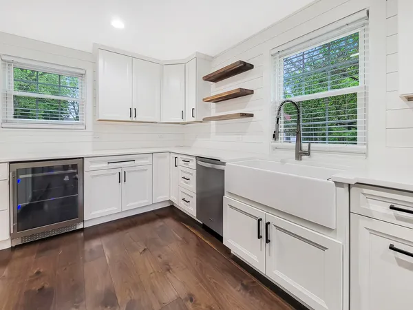 a kitchen with a sink cabinets appliances and a window