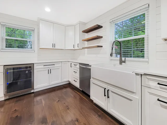 a kitchen with a sink cabinets appliances and a window