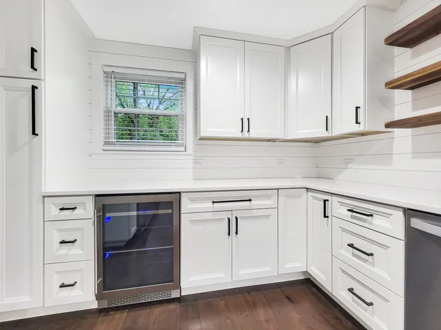 a kitchen with white cabinets and appliances