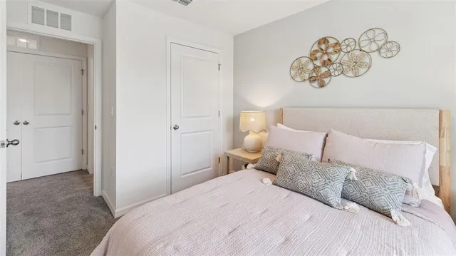 a bedroom with a bed and painting on the wall