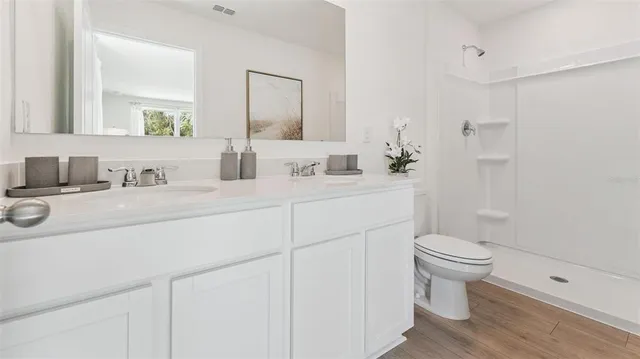 a bathroom with a sink toilet a mirror and shower