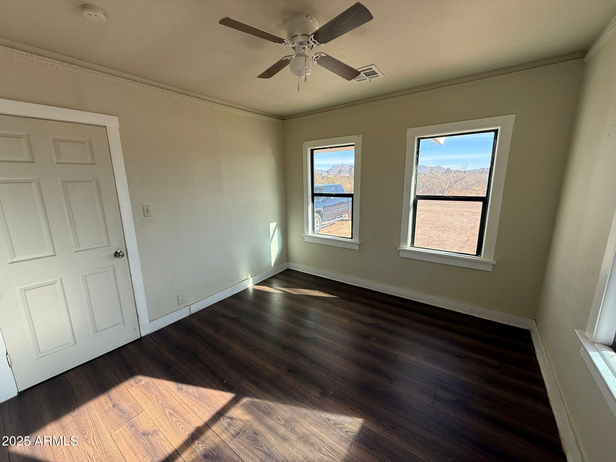 2082 North Cougar Place Douglas, AZ 85607 - Photo 13 of 16 a view of an empty room with a window and wooden floor