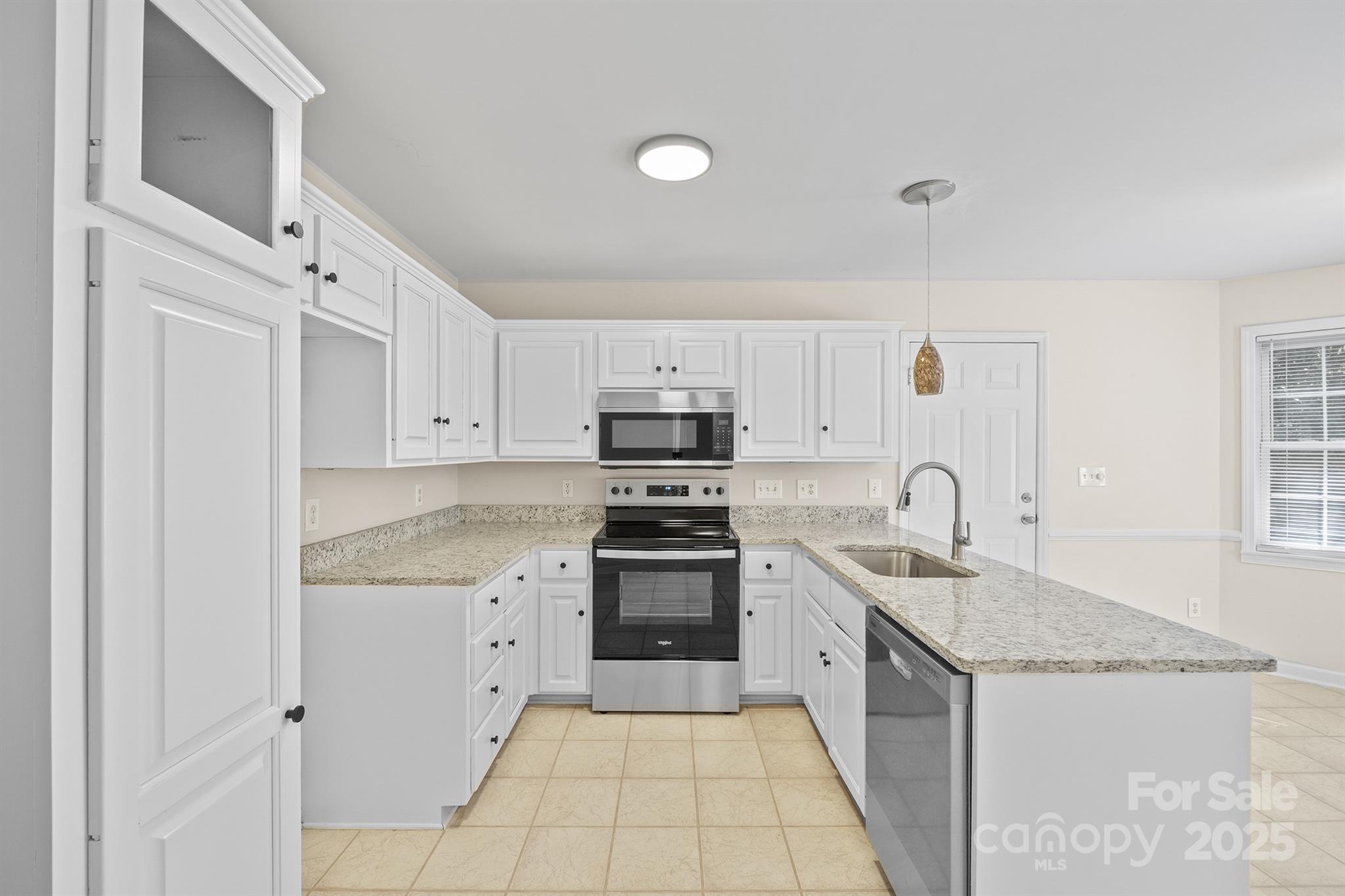 3024 Cross Tie Lane Matthews, NC 28105 - Photo 9 of 30 a kitchen with stainless steel appliances granite countertop a sink and dishwasher a stove top oven with white cabinets