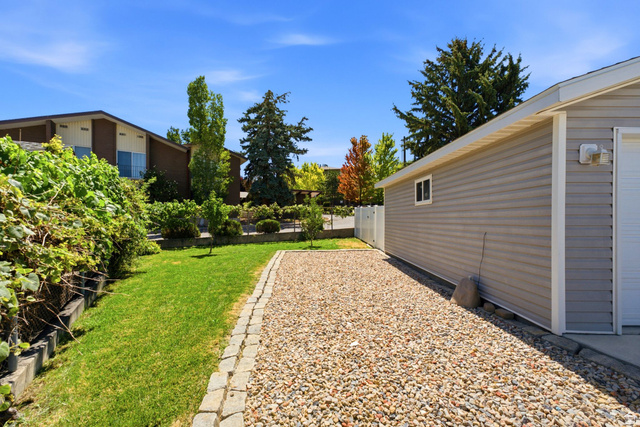 1925 South Main Street Bountiful, UT 84010 - Photo 31 of 48 Gravel driveway with paver edging, leading to a gray vinyl-sided garage