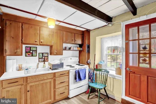 a kitchen that has a lot of cabinets in it and wooden floors