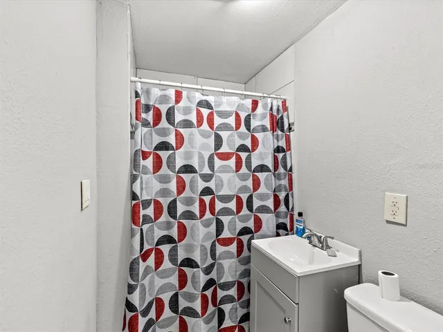 a bathroom with a sink and mirror with toilet