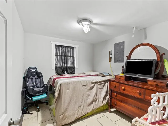 a bedroom with a bed and a tv on the dresser