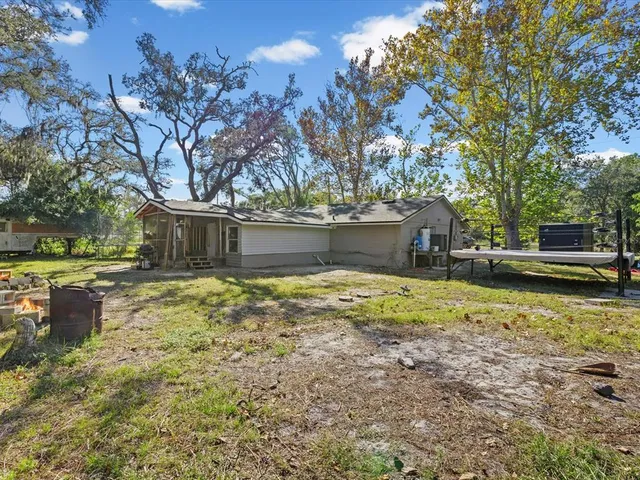 a view of a swimming pool with chairs in front of house